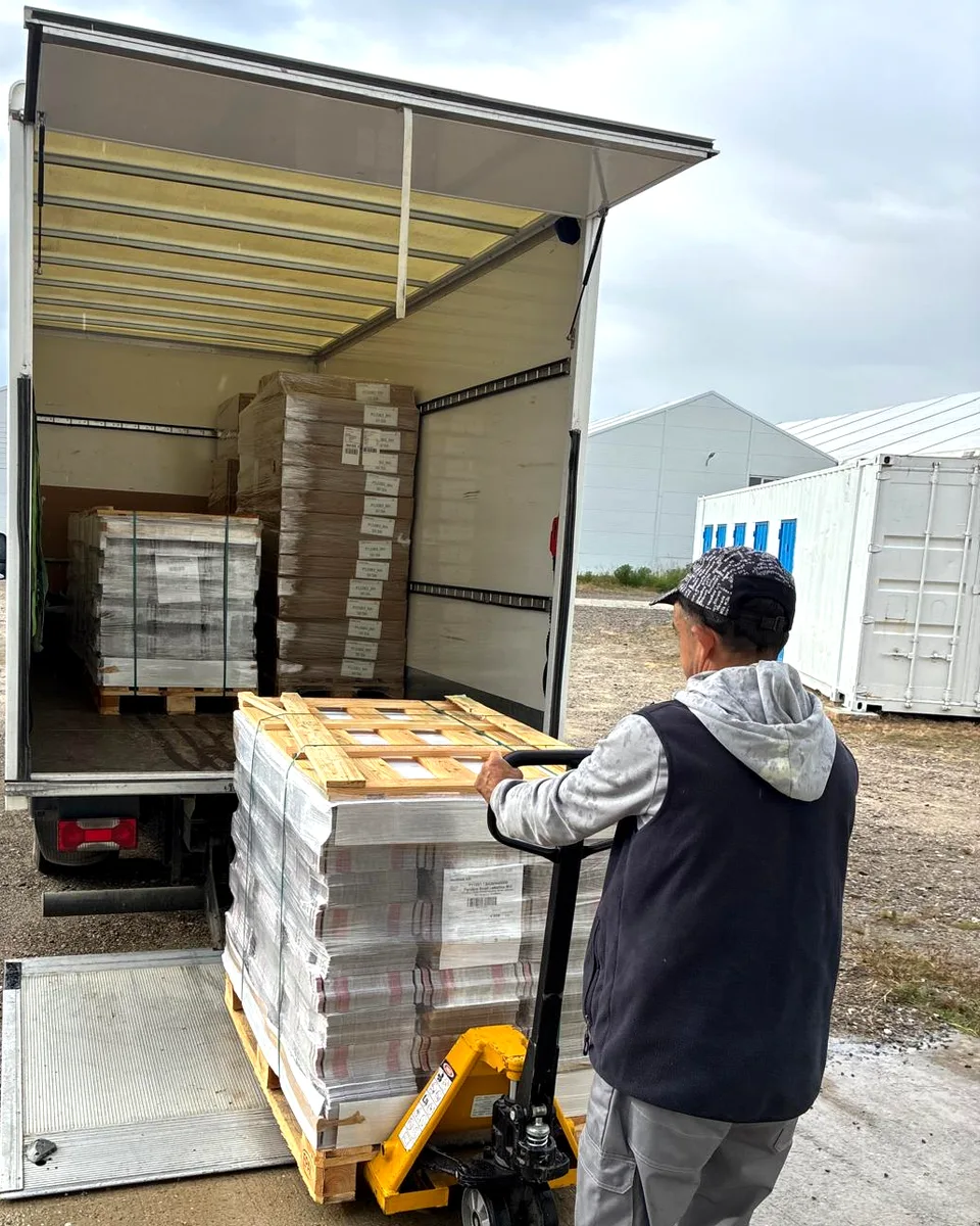 Marfă paletizată împinsă cu transpaletul spre camionul WEMOVE pentru livrare în București