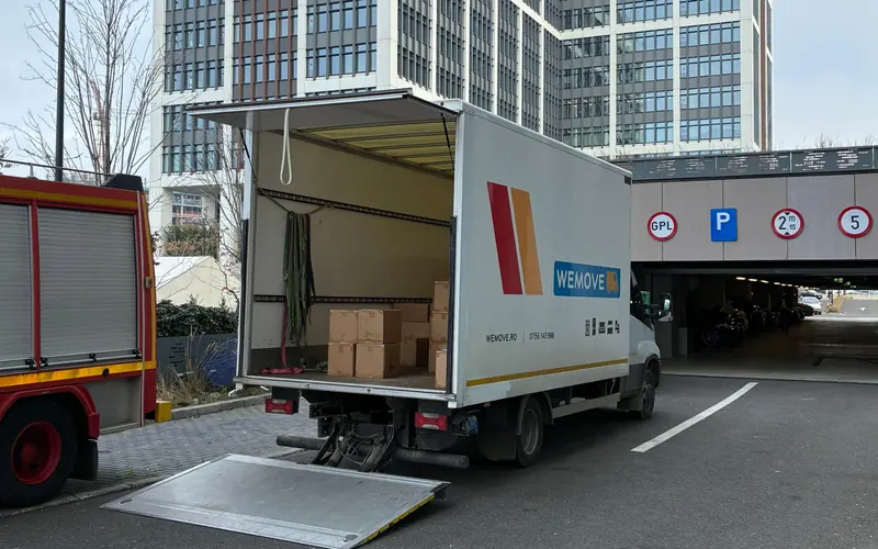Camion WeMove cu lift hidraulic coborât, încărcat cu cutii pentru transport marfă